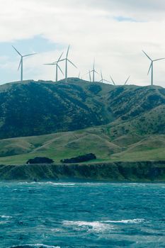 Windfarm wind turbines providing green alternative energy visible on the skyline in mountainous terrain