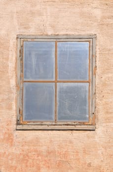 Single blank window on a cracked plastered wall.