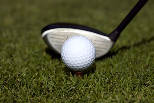 Close up of a golfball on a tee with a three wood