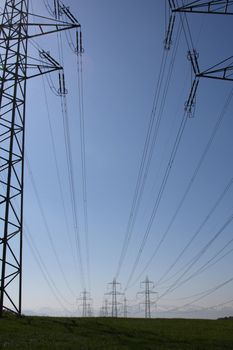 power lines over a meadow with mountains in the background