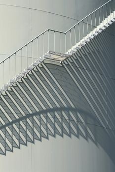 stairs and their shadows on a oil storage