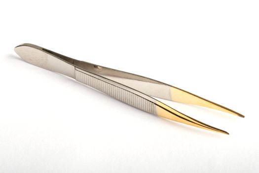 Silver eyebrow tweezers with golden tips on white background