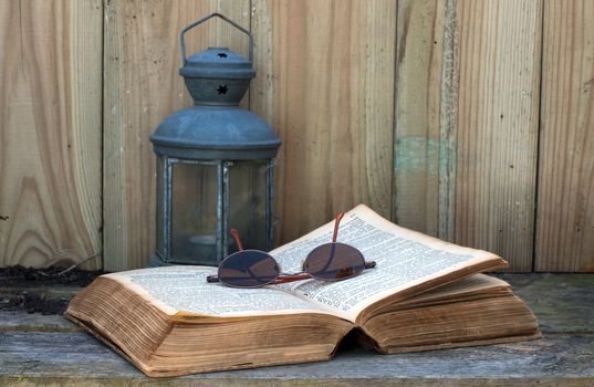 old bible still life with light and glasses