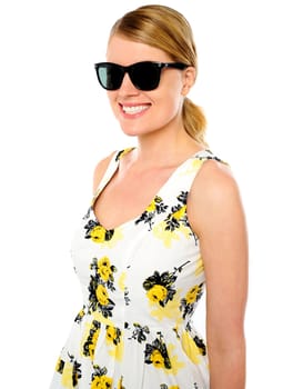 Smiling young woman wearing sunglasses over white background