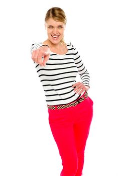 Trendy teenager posing in style while points at you. All on white background