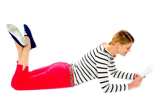 Smiling young woman using tablet pc. Lying on floor