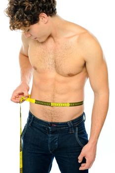 Muscular man measuring his waist isolated on white background