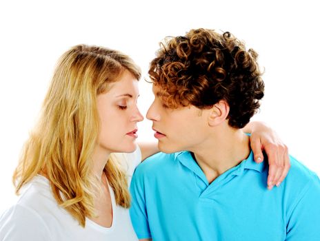 Beautiful young couple about to kiss against white background