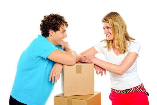 Lovable young smiling couple with boxes looking into each others eyes. Love concept
