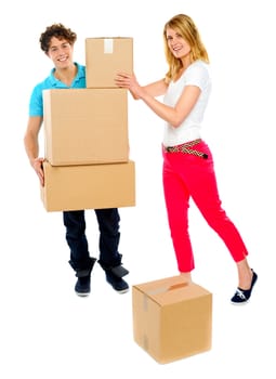 American woman placing boxes as guy holds the stack. All on white background