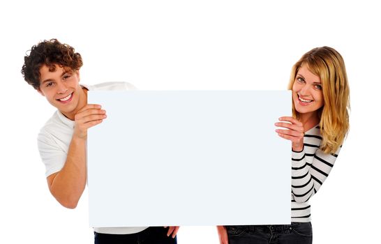 Attractive smiling couple holding a blank whiteboard. Isolated