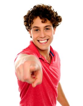 Handsome curly hair teen pointing at you. Dressed in casuals