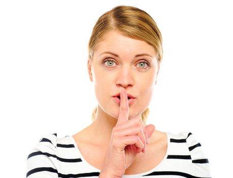 Female with wide open eyes gesturing silence against white background