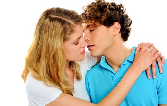 Teenage couple about to kiss each other isolated against white background