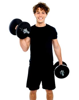 Muscular man doing exercise using bumbbells against white background