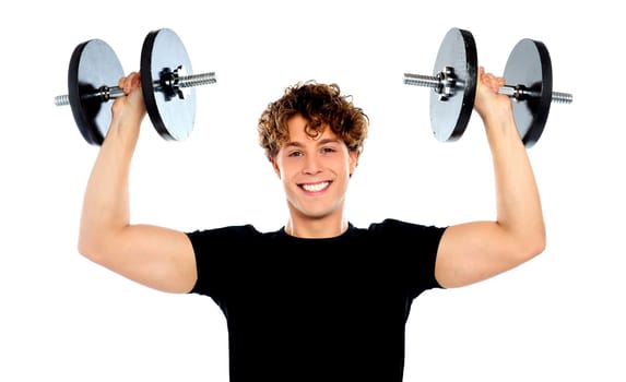Smiling athlete wearing sporty outfit, lifting weights