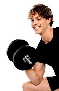 Muscular man in black sportswear with dumbbell looking away