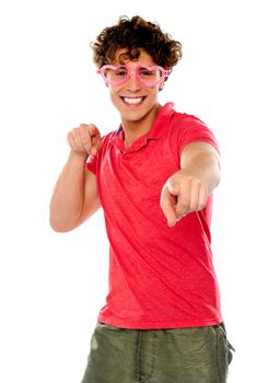 Handsome guy pointing at camera wearing heart shape pink glasses