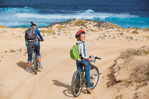 Girl with her mother having a weekend excursion on their bikes on a summer day in beautiful landscape