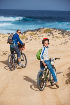 Girl with her mother having a weekend excursion on their bikes on a summer day in beautiful landscape. Vertical view