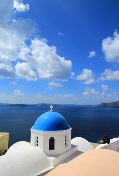 Famous blue dome of orthodox church on the sea background in Oia, Santorini, Greece.
