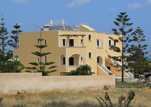Traditional yellow house and trees at Santorini island, Greece