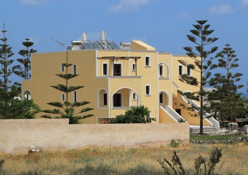 Traditional yellow house and trees at Santorini island, Greece