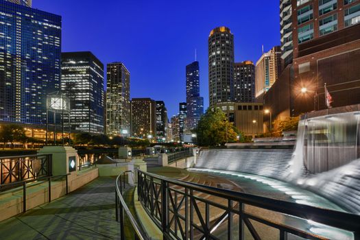 Floodlit Centennial Fountain and river side walk in Chicago at night