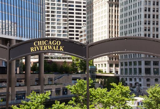 Brown arched sign to Chicago Riverwalk with tribune tower in background