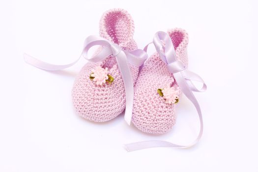 baby pink knitted booties isolated on white