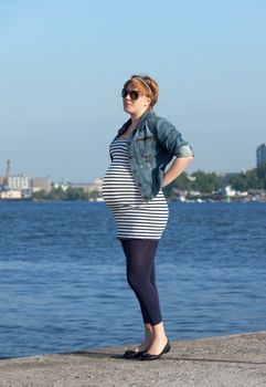 Pregnant Woman on Pier in the Urban Landscape