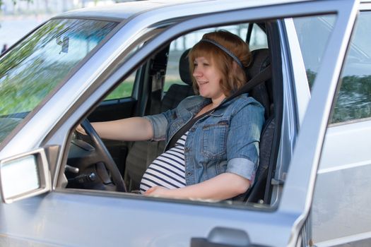 Pregnant woman in driving seat of the car