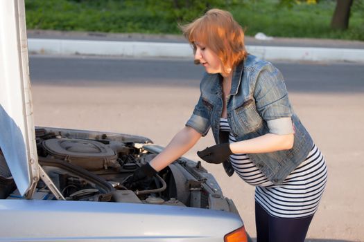 Pregnant Woman Trying to Repair the Car