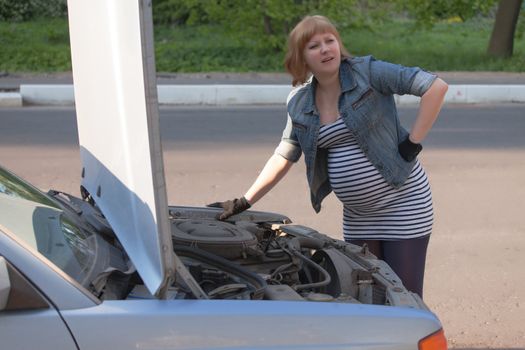 Pregnant Woman Trying to Repair the Car