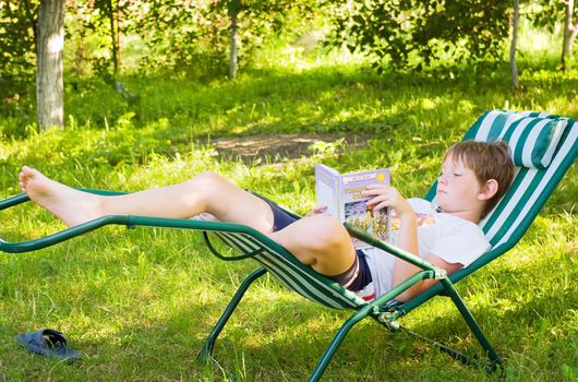 Boy in silence in the garden reading a book 