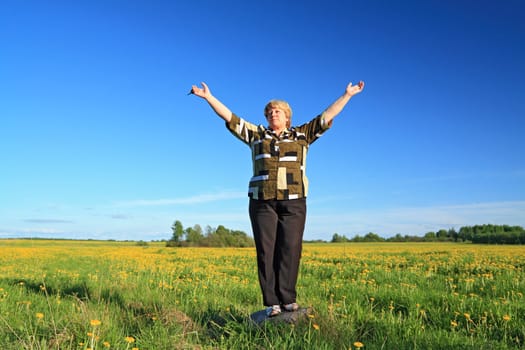 woman on stone amongst summer field