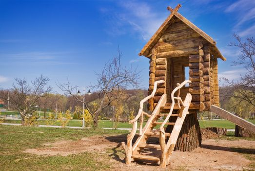 a wooden small fabulous house with  hill at the playground
