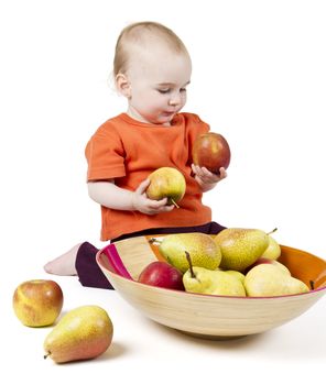 baby with apples and pears laying in bowl - studio shot