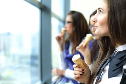 women on foreground licking ice cream 