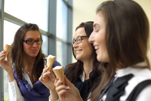 women on foreground licking ice cream 