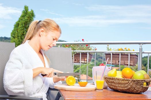 Woman making morning juice on terrace