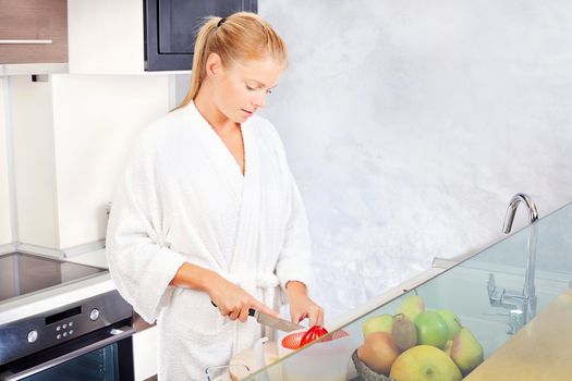 pretty woman making morning juice in kitchen