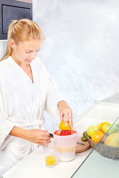 pretty woman making morning juice in kitchen