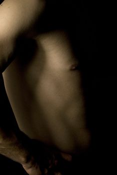 sexy fit naked male body on black background low key