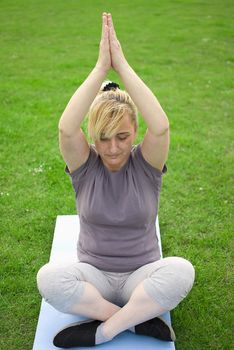 middle aged woman keeping fit with exercises in a park