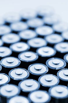Tops of many AA batteries in closeup