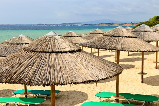 Beach umbrellas on sandy resort coast in Greece