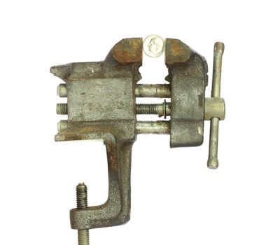 Dime squeezed tightly in a metal bench vice