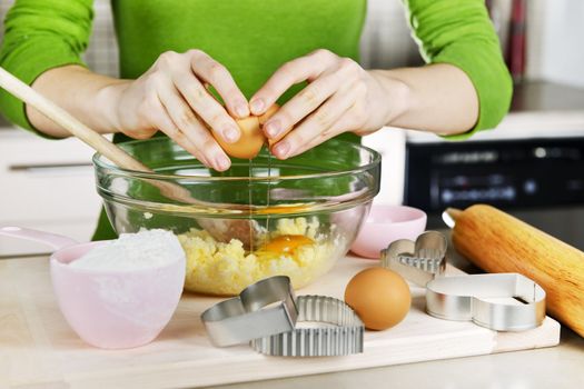 Cracking egg into mixing bowl making cookies