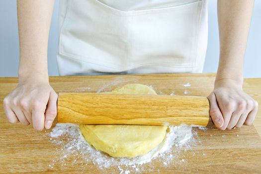 Spreading out cookie dough with wooden rolling pin